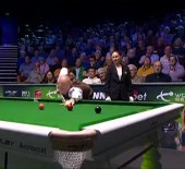 A snooker table in a packed arena
